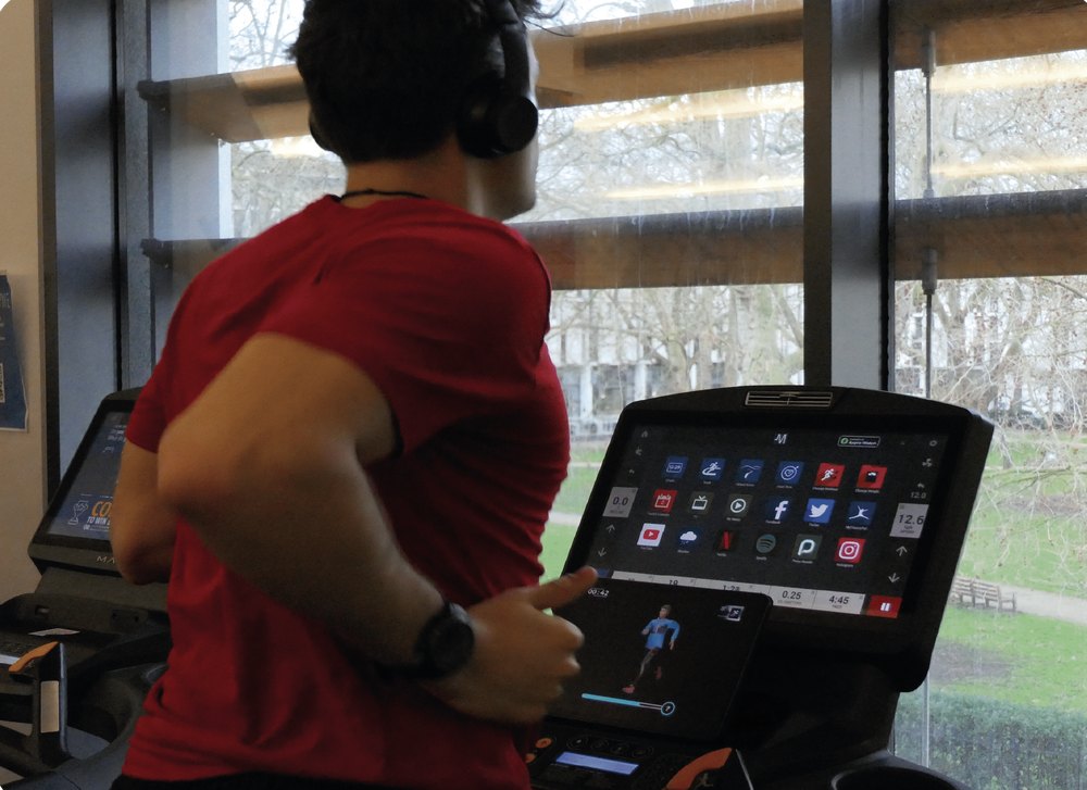 A participant running while their avatar plays on the treadmill screen